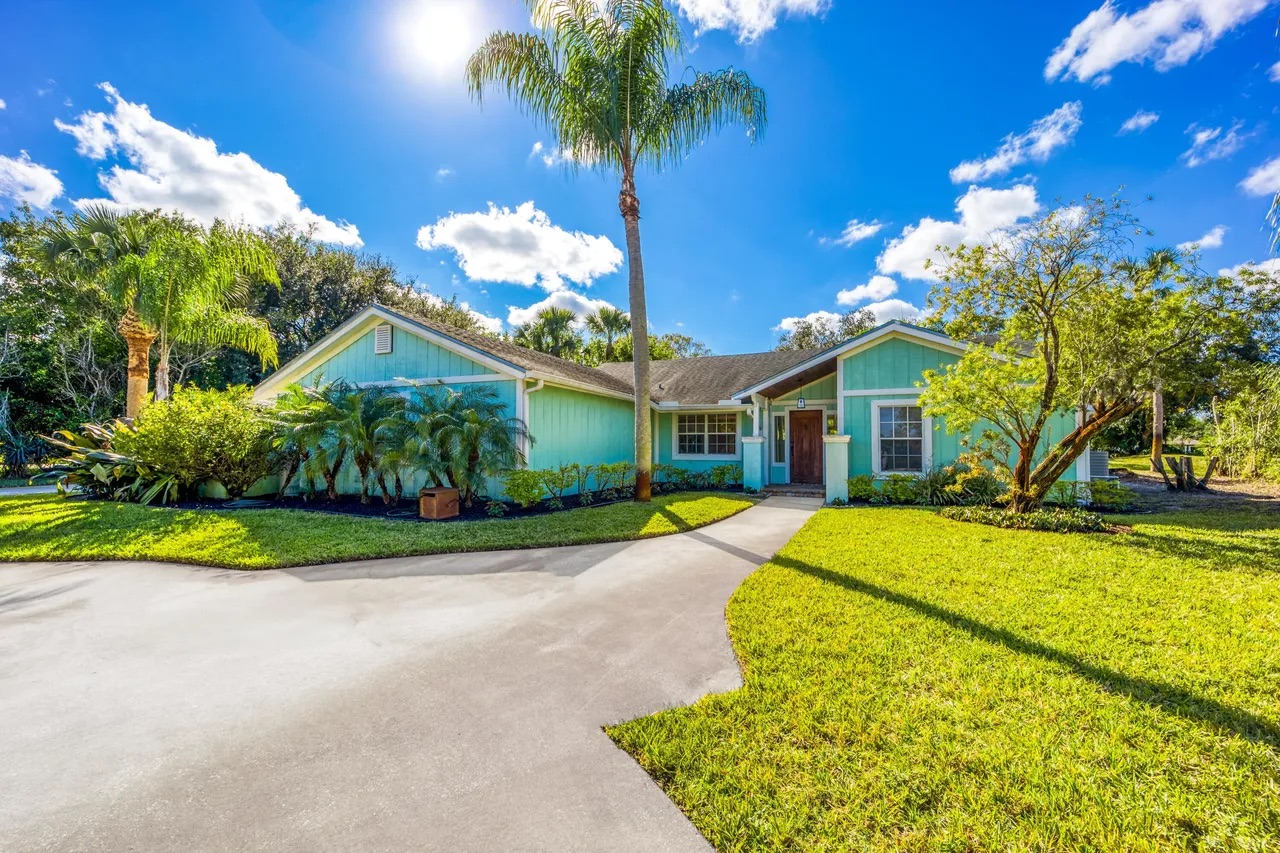 Single-story home framed by palms at 2232 SW Racquet Club Dr, Palm City, FL